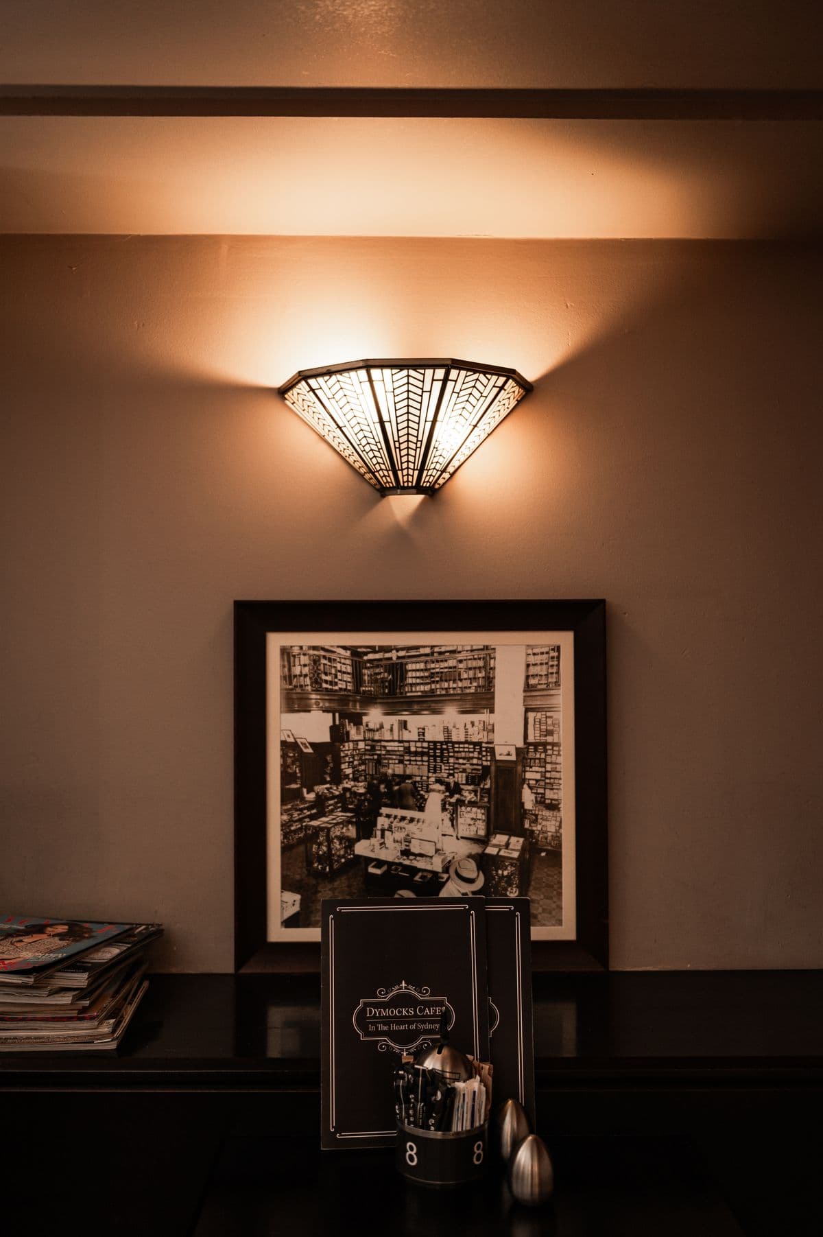 Art deco wall sconce and vintage bookshop photograph at Dymocks Cafe